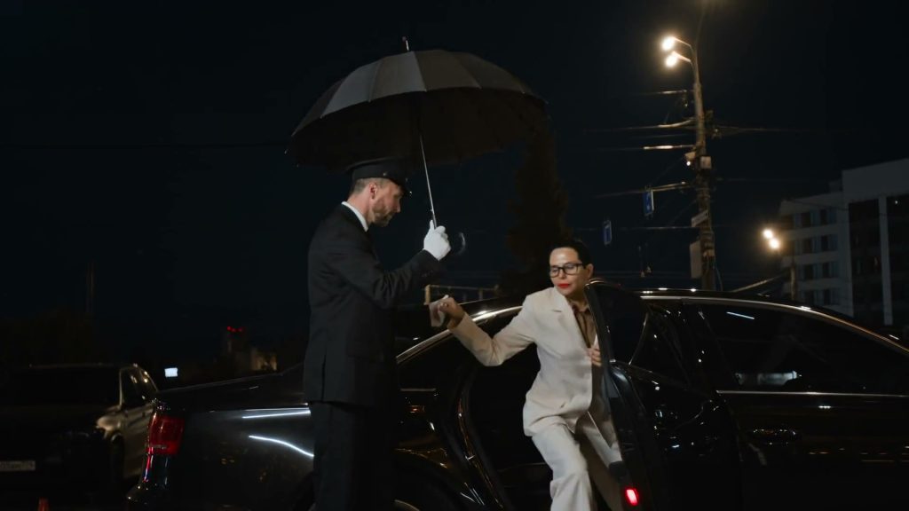 KTC chauffeur holding an umbrella while a guest steps out of a luxury car